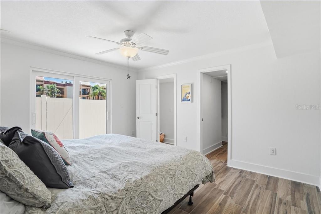 8911 Blind Pass Road, Unit 118 St. Pete Beach, FL 33706 - Photo 26 of 34 a bedroom with a bed and a chandelier