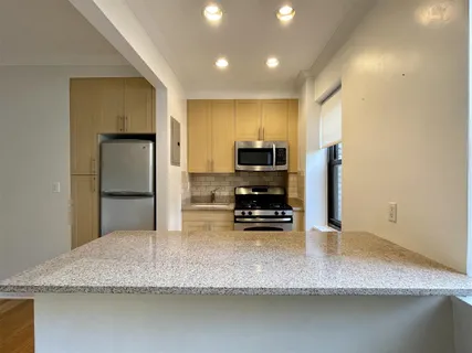 a kitchen with stainless steel appliances granite countertop a sink refrigerator and microwave