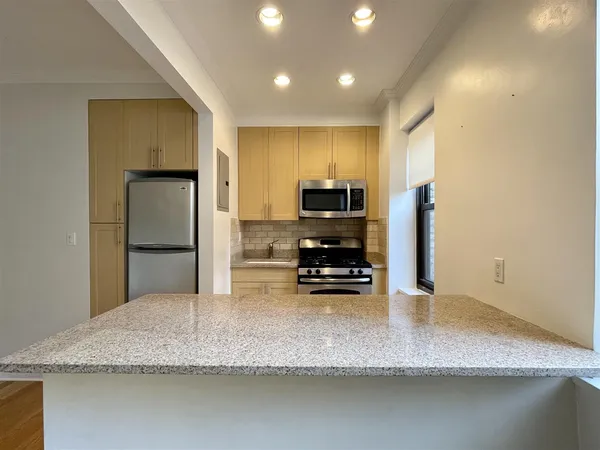 a kitchen with stainless steel appliances granite countertop a sink refrigerator and microwave