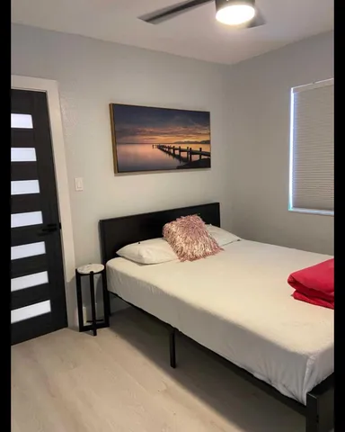 a bedroom with a bed and a lamp on dresser