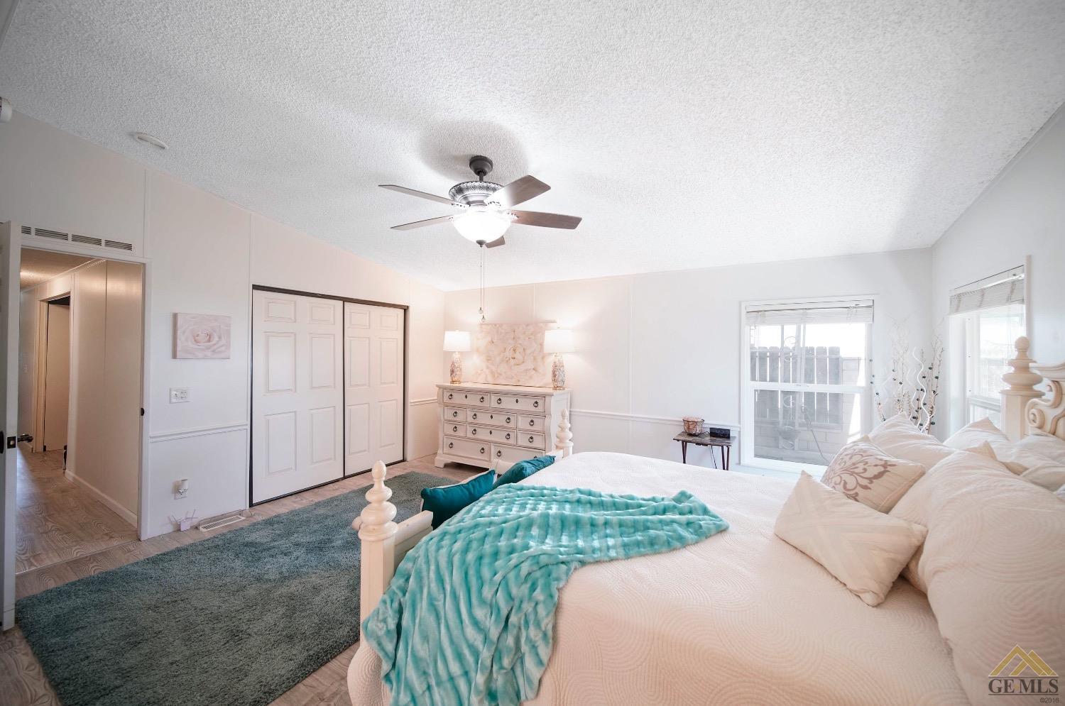 Undisclosed Address Bakersfield, CA 93308 - Photo 11 of 25 a bedroom with a large bed and a chandelier
