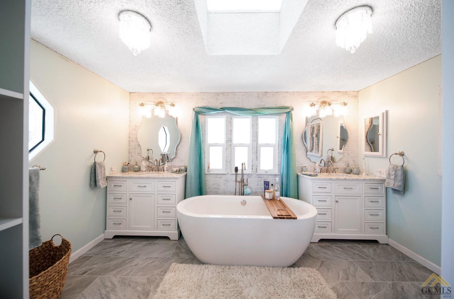 Undisclosed Address Bakersfield, CA 93308 - Photo 12 of 25 a spacious bathroom with a double vanity sink a mirror and a bathtub