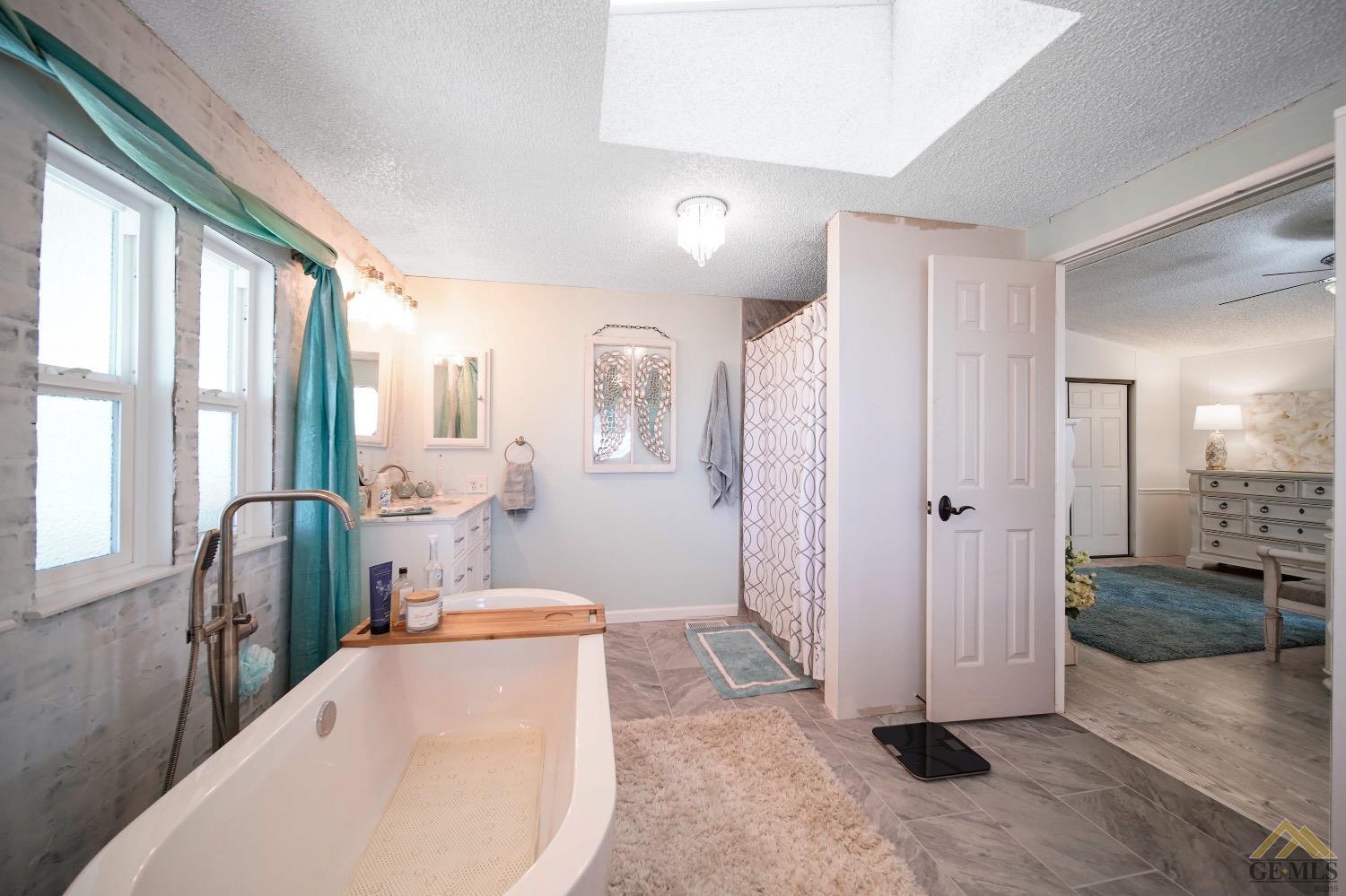 Undisclosed Address Bakersfield, CA 93308 - Photo 13 of 25 a bathroom with a tub sink and mirror