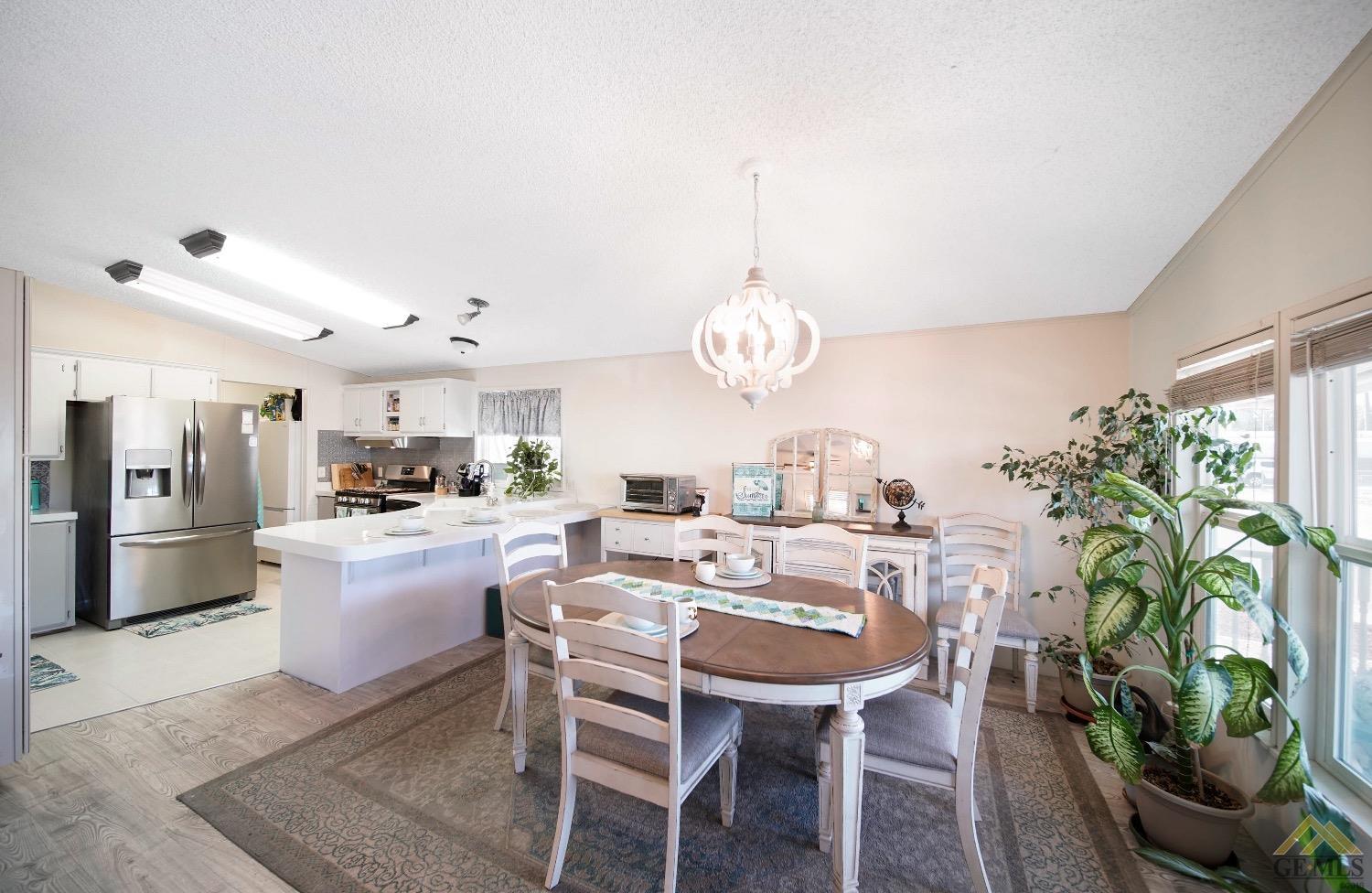 Undisclosed Address Bakersfield, CA 93308 - Photo 17 of 25 a view of a dining room with furniture a chandelier and wooden floor