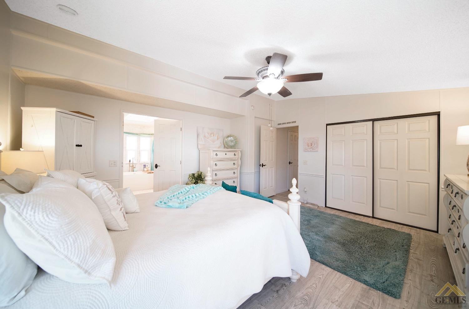 Undisclosed Address Bakersfield, CA 93308 - Photo 10 of 25 a spacious bedroom with a bed and a chandelier