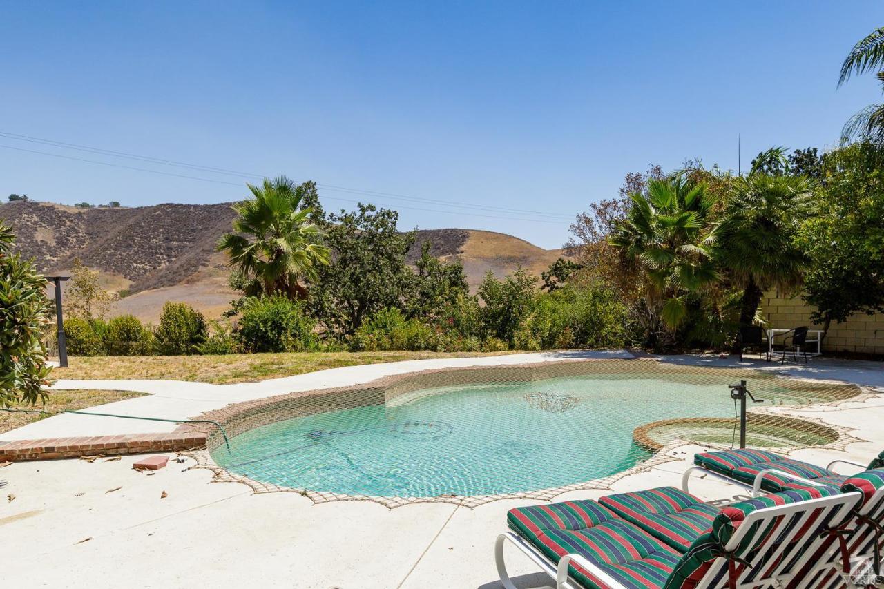 5534 Parkmor Road Calabasas, CA 91302 - Photo 5 of 29 a backyard of a house with table and chairs under an umbrella