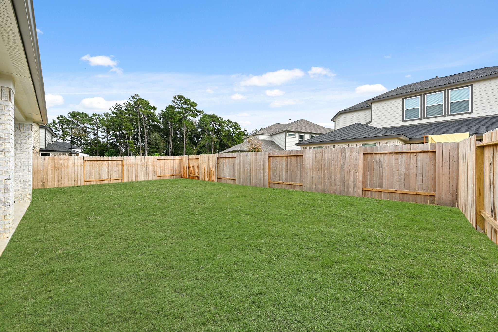 3308 Pin Cherry Lane Conroe, TX 77301 - Photo 36 of 45 a view of a backyard with table and chairs and wooden fence