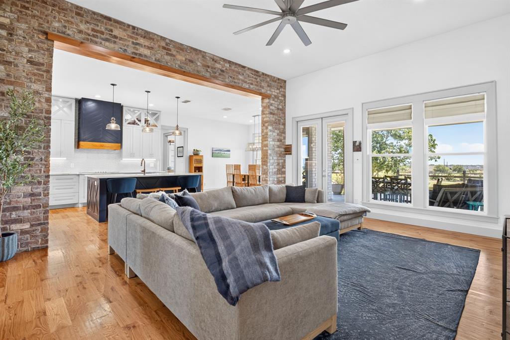 3008 Perkins Weatherford, TX 76088 - Photo 10 of 36 Open-concept living space featuring wood-finish flooring, a contemporary ceiling fan, and large windows
