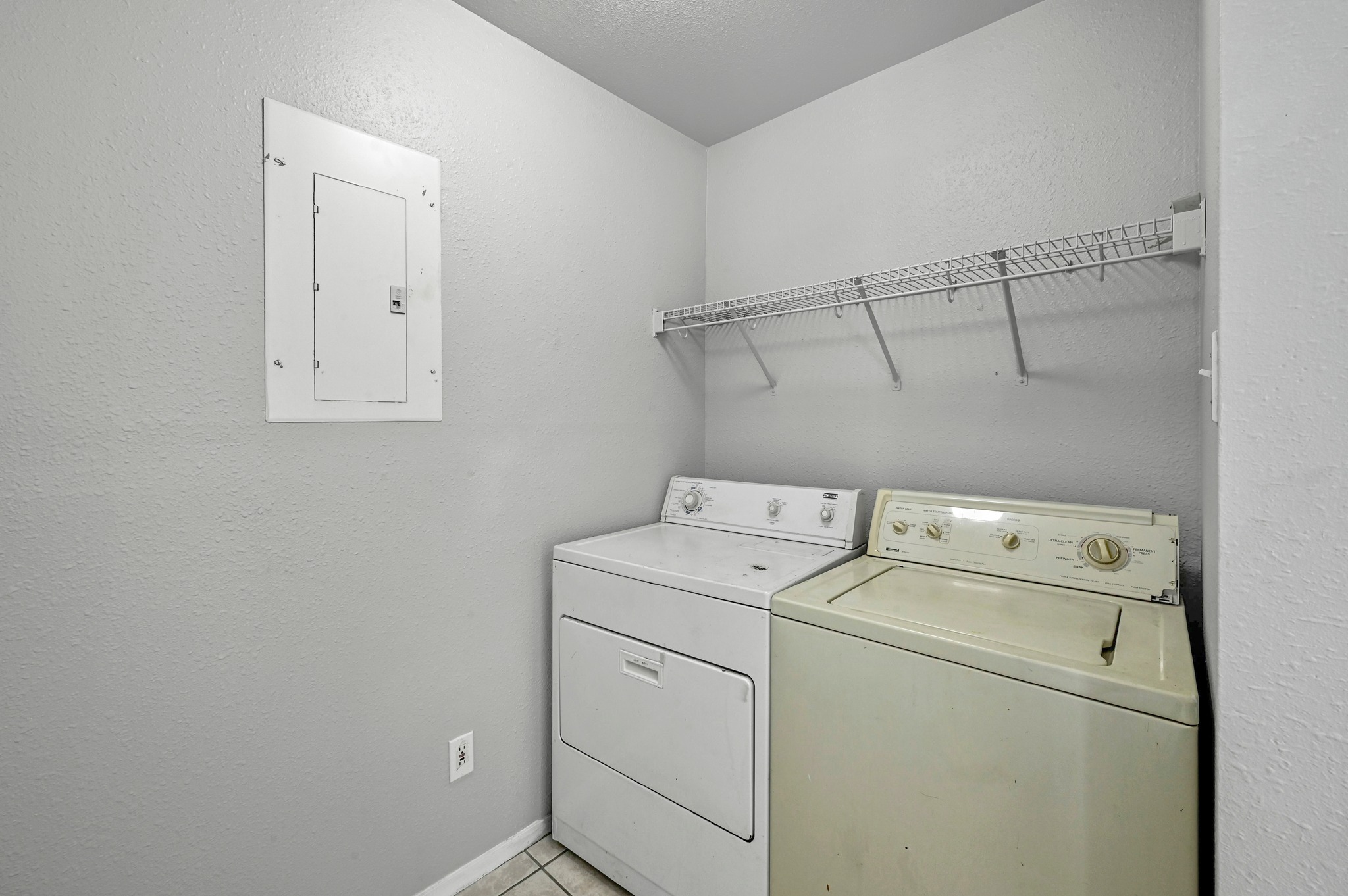 2212 Katy Lane Georgetown, TX 78626 - Photo 24 of 27 Utility space featuring neutral-toned walls, tile flooring, and a wall-mounted shelving unit