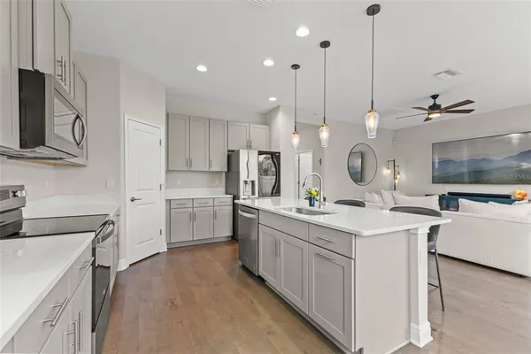 a kitchen with kitchen island a sink appliances and cabinets