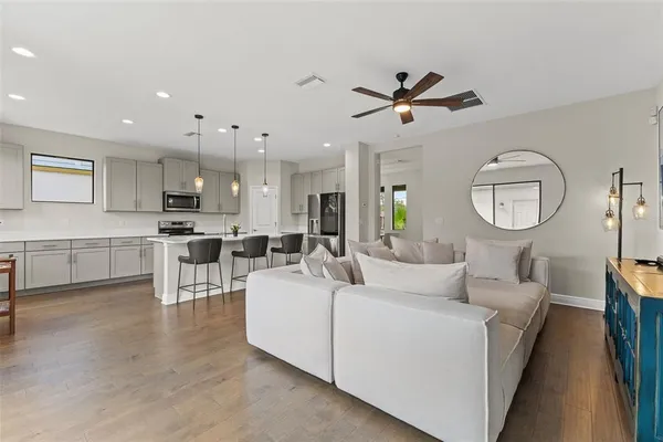 a living room with furniture a clock and a ceiling fan