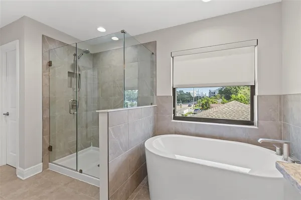 a bathroom with a tub shower and window