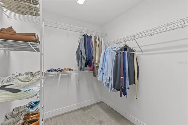a view of walk in closet with clothes and shoes
