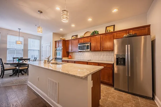 a kitchen with stainless steel appliances granite countertop a sink refrigerator and cabinets
