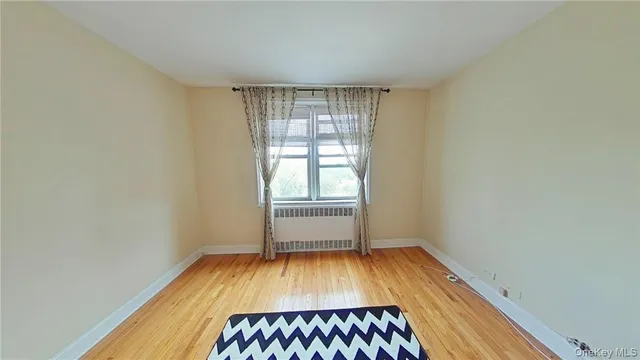 a view of a room with wooden floor and bench