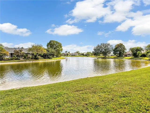 an empty room with chandelier fan and windows