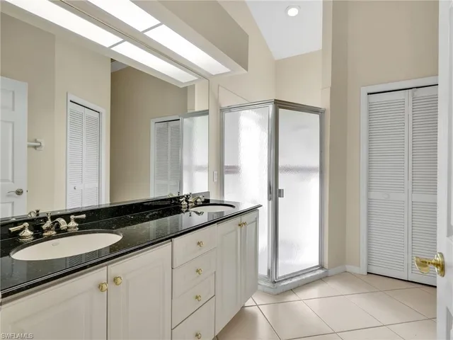 a room with granite countertop a sink and a mirror