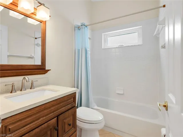 an empty room with windows and chandelier fan