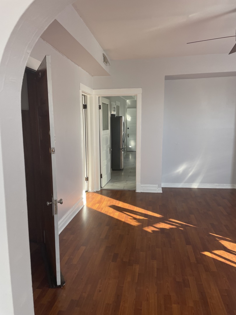 1511 North Keystone Avenue, Unit 2 Chicago, IL 60651 - Photo 3 of 8 an empty room with wooden floor and windows