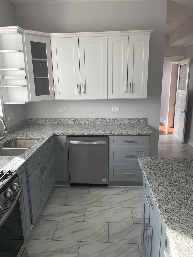 1511 North Keystone Avenue, Unit 2 Chicago, IL 60651 - Photo 5 of 8 a kitchen with granite countertop a sink a stove and cabinets