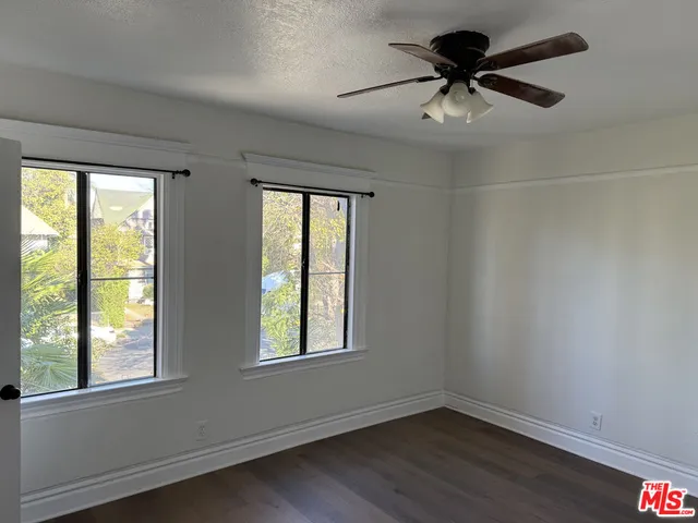 an empty room with a window and a fan