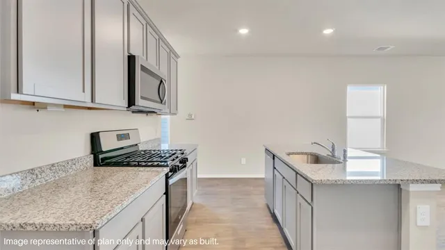 a kitchen with stainless steel appliances granite countertop a sink stove and cabinets