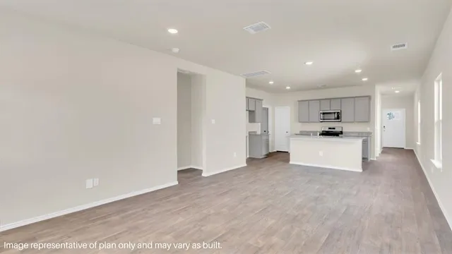 a view of a kitchen with refrigerator and white cabinets