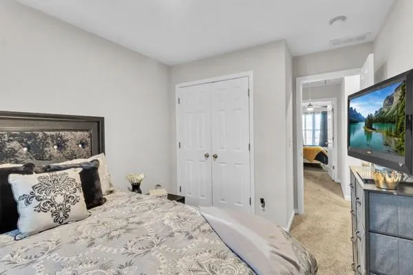 a bedroom with a large bed couch and a flat screen tv