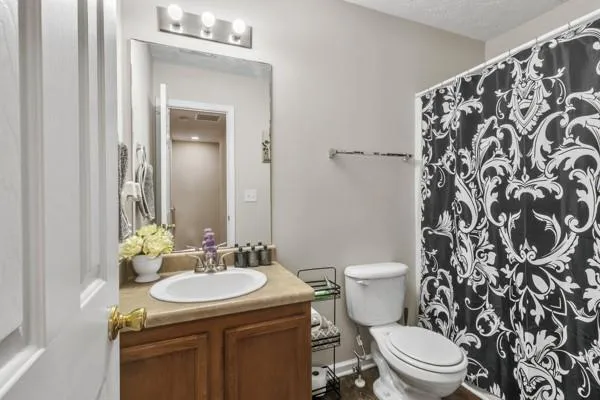 a bathroom with a granite countertop toilet sink and mirror