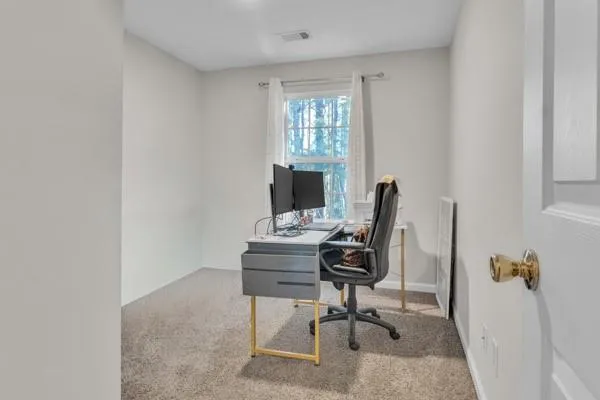 a view of a workspace with furniture and a window