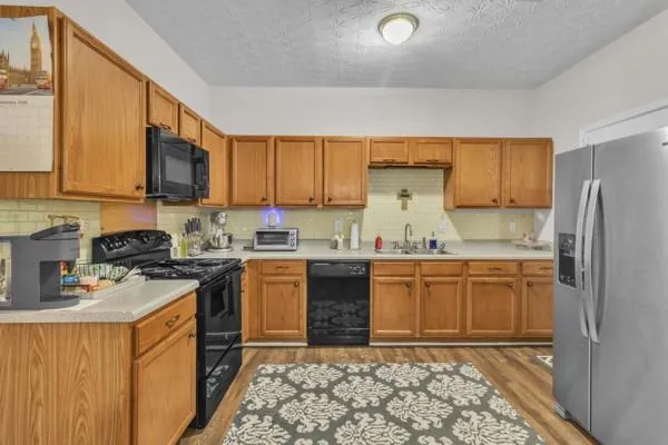 a kitchen with stainless steel appliances granite countertop a stove a sink dishwasher and a refrigerator