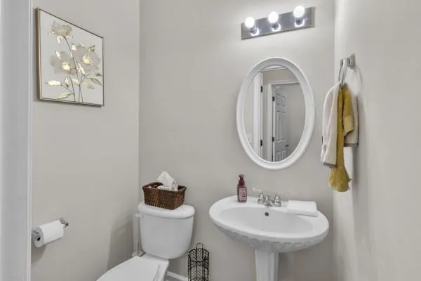 a bathroom with a toilet a sink and a mirror