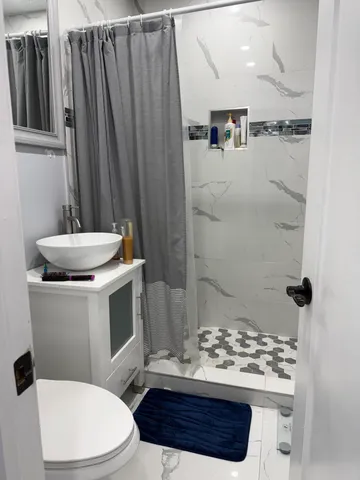 a bathroom with a sink a toilet and shower