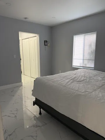 a bed sitting in a bedroom next to a window