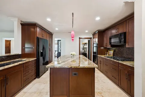 a kitchen with kitchen island granite countertop stainless steel appliances and a sink
