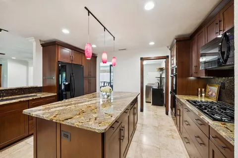 a kitchen with kitchen island a sink stove and refrigerator