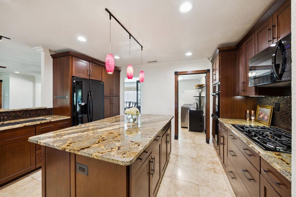 14380 Olympic Drive Farmers Branch, TX 75234 - Photo 12 of 33 a kitchen with kitchen island a sink stove and refrigerator