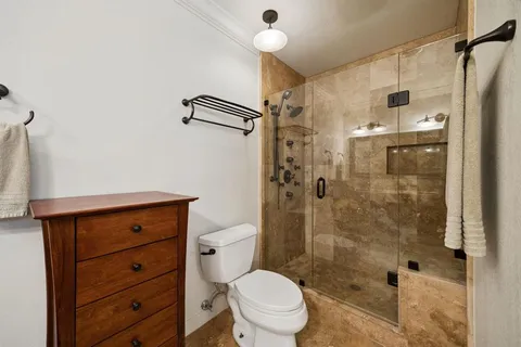 a bathroom with a shower a sink and toilet