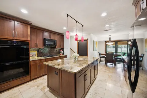 a kitchen with granite countertop a stove refrigerator and microwave