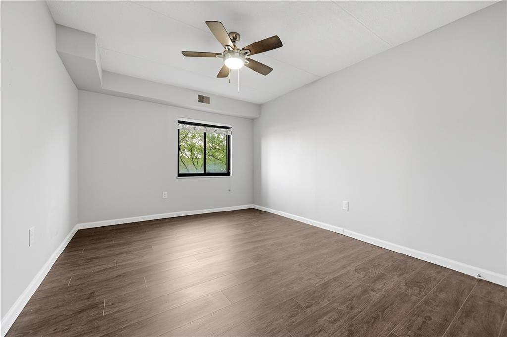 5600 Munhall Road, Unit 309 Pittsburgh, PA 15217 - Photo 17 of 40 an empty room with wooden floor ceiling fan and window
