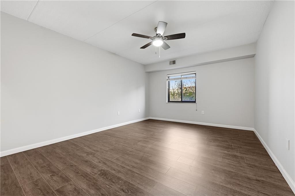5600 Munhall Road, Unit 309 Pittsburgh, PA 15217 - Photo 19 of 40 an empty room with wooden floor chandelier fan and windows