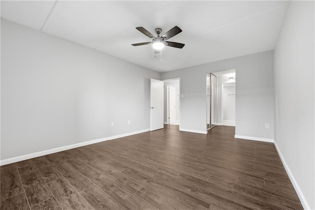 5600 Munhall Road, Unit 309 Pittsburgh, PA 15217 - Photo 23 of 40 a view of an empty room with wooden floor and a ceiling fan