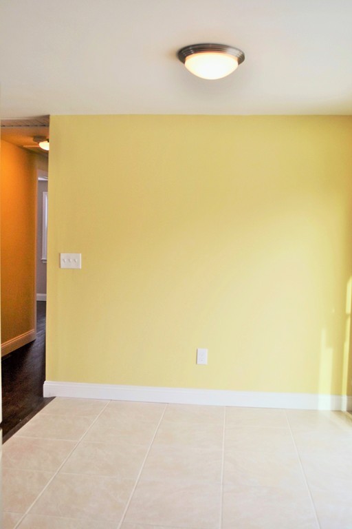 29 East Hill Road Springfield, MA 01109 - Photo 6 of 19 an empty room with a wooden floor and a large window