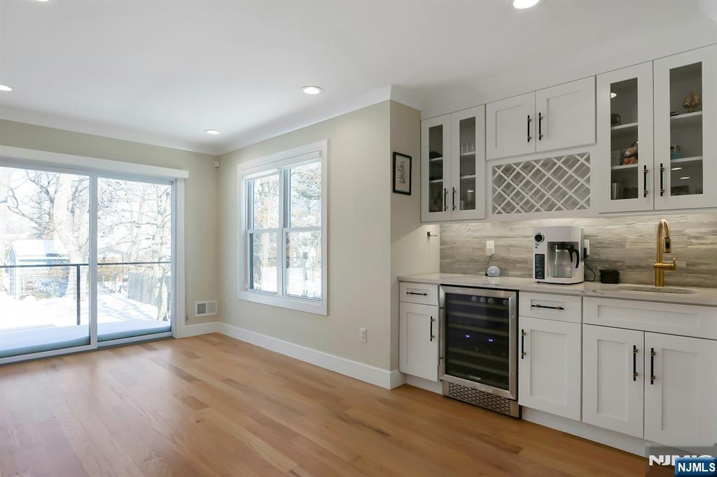 676 Ridgewood Avenue Oradell, NJ 07649 - Photo 14 of 47 a kitchen with stainless steel appliances granite countertop a stove a sink and white cabinets with wooden floor next to windows