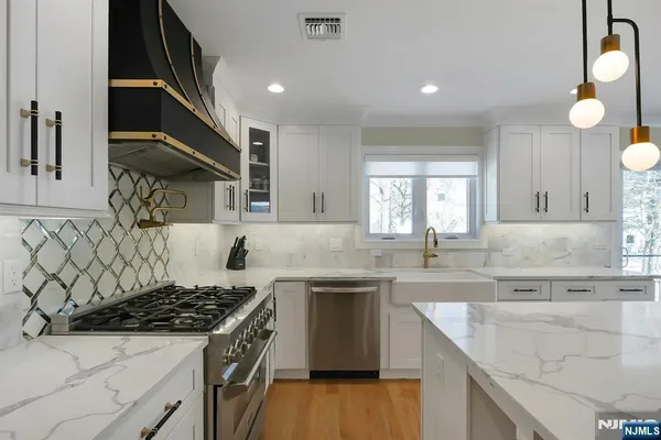 a kitchen with stainless steel appliances granite countertop a sink stove and cabinets
