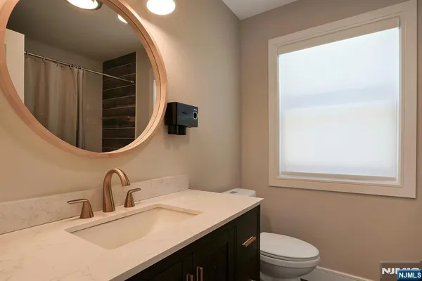 a bathroom with a sink vanity mirror and toilet