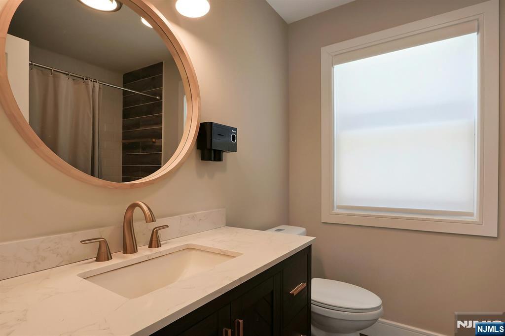 676 Ridgewood Avenue Oradell, NJ 07649 - Photo 24 of 47 a bathroom with a sink vanity mirror and toilet