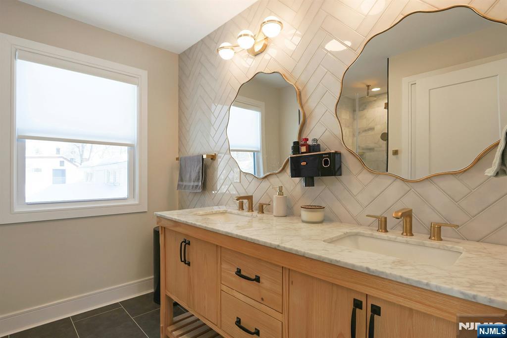 676 Ridgewood Avenue Oradell, NJ 07649 - Photo 28 of 47 a bathroom with a double vanity sink and a mirror
