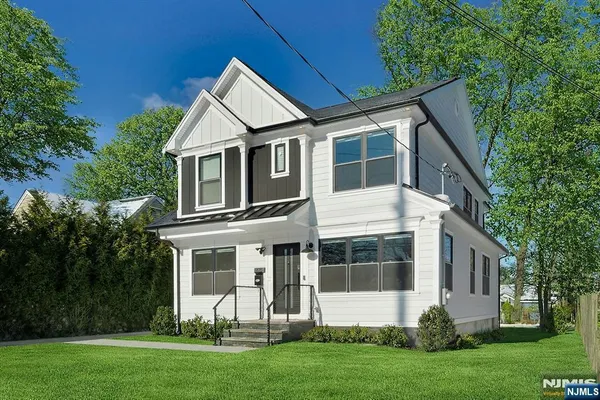 a front view of a house with a yard and trees
