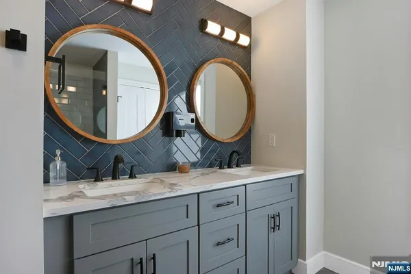 a bathroom with a granite countertop double vanity sink and a mirror